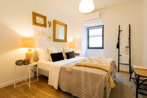 a bedroom with a bed and a table with a lamp at Espaço Calheta in Ponta Delgada
