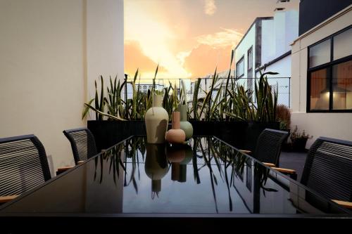 a table with chairs and a vase on top of it at Espaço Calheta in Ponta Delgada
