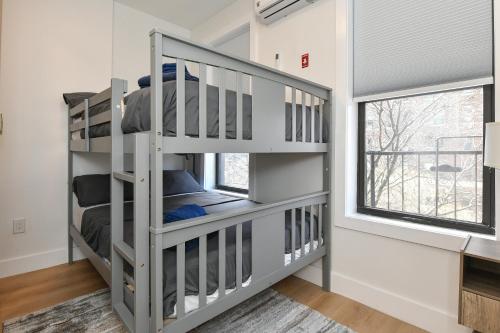 a bedroom with two bunk beds and a window at Chic 2BR Stay-Steps From Central Park in New York