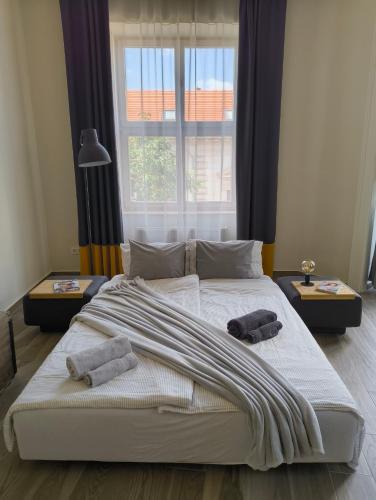 a large bed in a bedroom with two towels on it at City Art Inn in Szeged