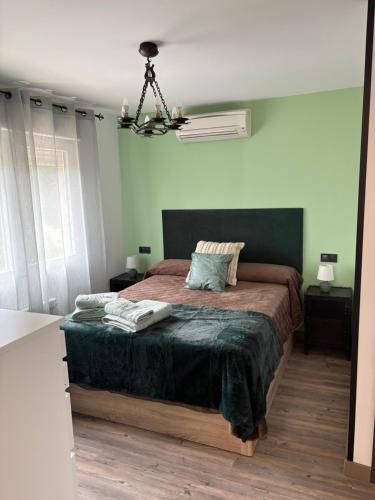 a bedroom with a bed and a chandelier at Sueña Toledo- Apartamentos turisticos con piscina in Toledo