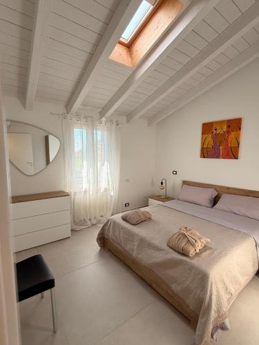 a bedroom with a large bed and a skylight at Oasi del Po in Monticelli dʼOngina