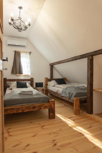 two twin beds in a room with a chandelier at Hárs Vendégház in Balatonendréd