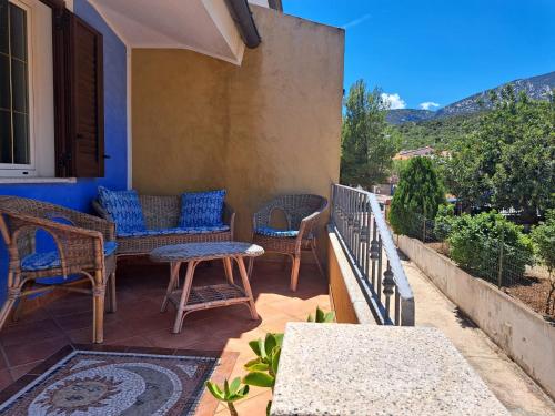 a patio with wicker chairs and tables on a house at Domus de mare in Cala Gonone