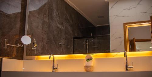 a bathroom with two sinks and a mirror at Hotel Privê do Atalaia in Salinópolis