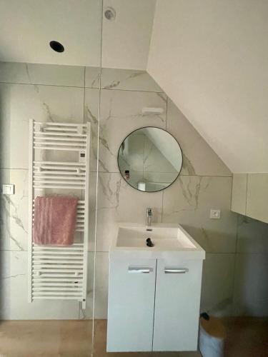 a white bathroom with a sink and a mirror at - Le 4ème Tourbillon- in Molsheim