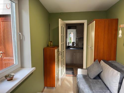 a living room with a couch and a kitchen at Lielupes Apartments Jurmala in Jūrmala