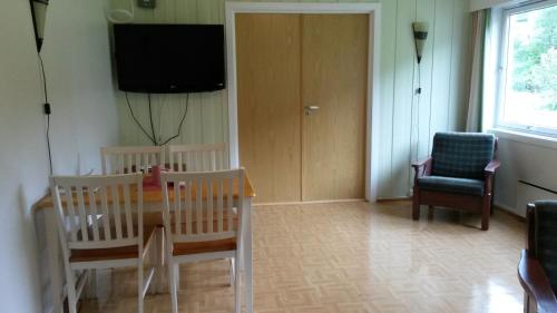 a dining room with a table and chairs and a television at HI Borlaug Vandrerhjem in Borgund