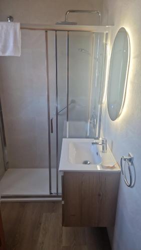 a small bathroom with a sink and a shower at Hotel Cuevas Del Mar in Nueva de Llanes