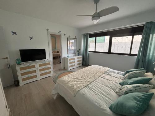 a bedroom with a bed and a flat screen tv at Beautiful house with ocean views in La Cala de Mijas