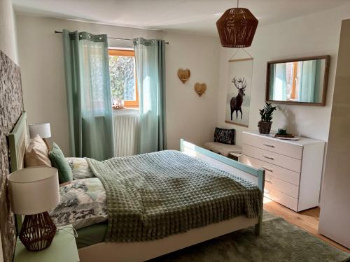 a bedroom with a bed and a dresser and a window at Grünes Stüble - Haustiere auf Anfrage in Altusried