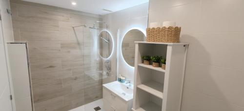 a white bathroom with a shower and a sink at Beautiful house with ocean views in La Cala de Mijas
