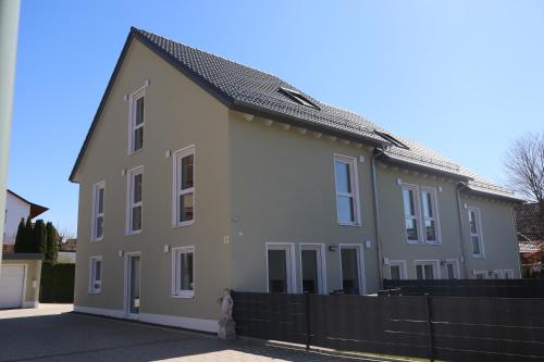 a large white house with a black fence at Ferienhaus Ferati - Modernes Neubau-Haus & nahe Legoland in Günzburg