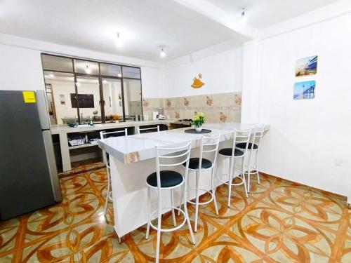 a kitchen with a large white island with stools at Casa Los Reyes in La Magdalena Atlipac