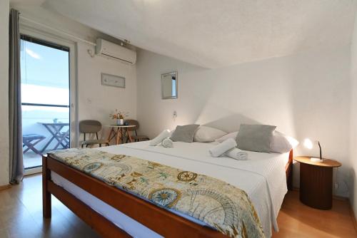 a bedroom with a large bed and a large window at Apartments Villa Arta in Murter