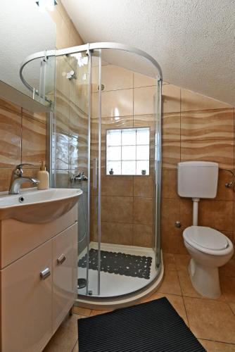 a bathroom with a shower with a toilet and a sink at Apartments Villa Arta in Murter