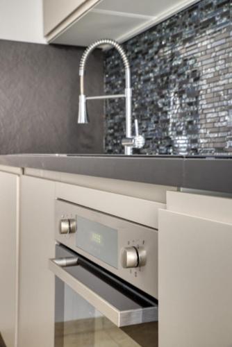 a white kitchen with a sink and a sink at Elegant apartment with pool and parking in Losone