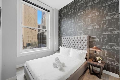 a bedroom with a bed with a black and white wallpaper at The Plymouth Chicago in Chicago