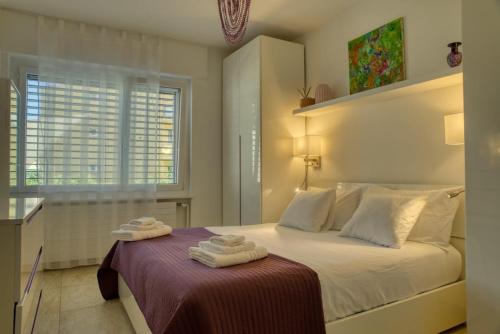 a bedroom with a bed with two towels on it at Elegant apartment with pool and parking in Losone
