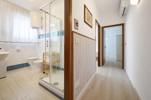 a bathroom with a glass shower and a toilet at Residenze Etruria in San Vincenzo