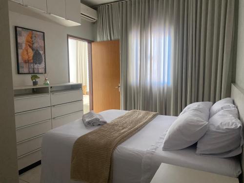 a bedroom with a bed with white sheets and pillows at Casa Betel in Anápolis