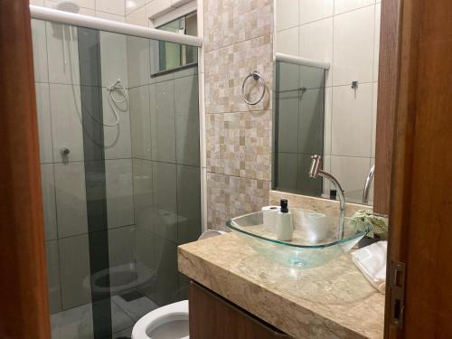 a bathroom with a glass bowl sink and a shower at Casa Betel in Anápolis