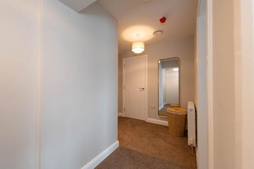 a room with a hallway with a mirror and a bathroom at Banbridge Central Stay in Banbridge