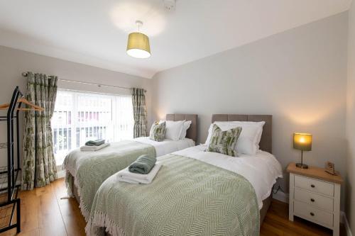 a bedroom with two beds and a window at Banbridge Central Stay in Banbridge