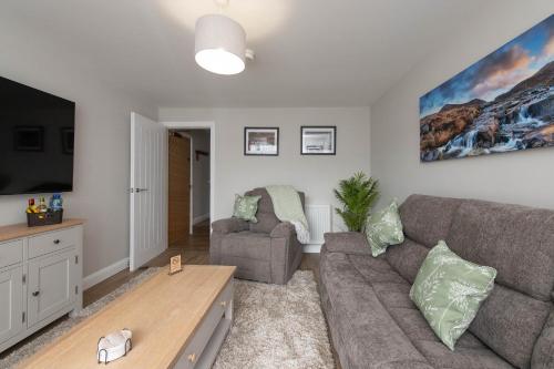 a living room with a couch and a tv at Banbridge Central Stay in Banbridge