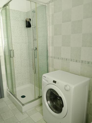 a washing machine in a bathroom with a shower at CASTEDDU rooms in Cagliari