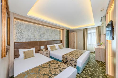 a hotel room with two beds and a television at Hotel Seren 2 in Istanbul