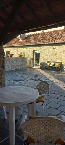 a patio with a table and chairs and a building at Casa do Fundão in Paredes