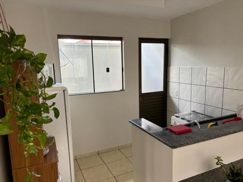a kitchen with a counter top and a refrigerator at Ap Perfeito! Condomínio fechado e garagem coberta in Tangara da Serra