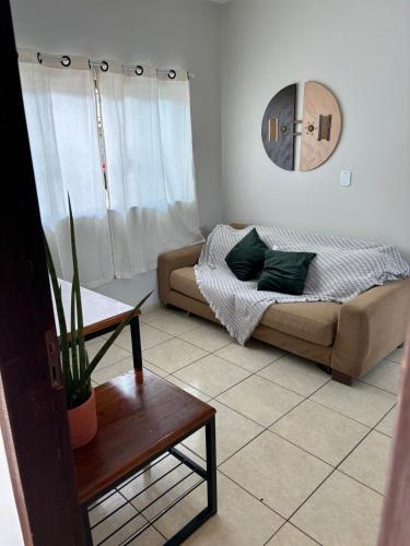 a living room with a couch and a table at Ap Perfeito! Condomínio fechado e garagem coberta in Tangara da Serra