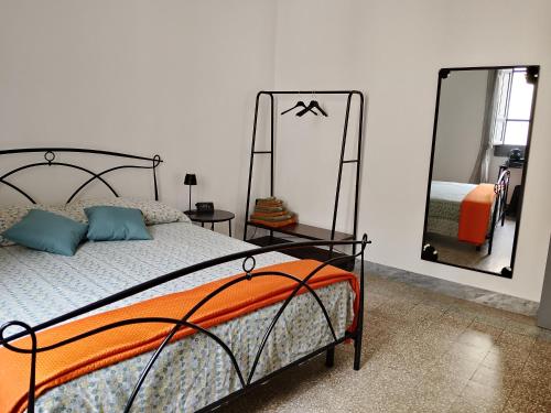 a bedroom with a bed and two mirrors at CASTEDDU rooms in Cagliari