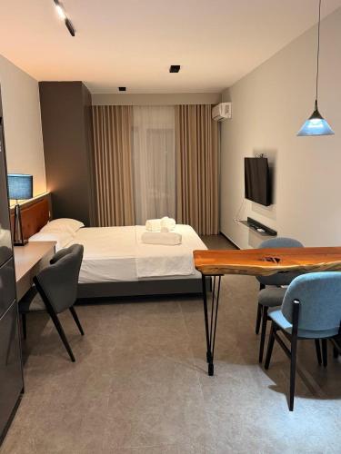 a hotel room with a bed and a table and chairs at Casa Del Sol Studio - Shengjin in Shëngjin
