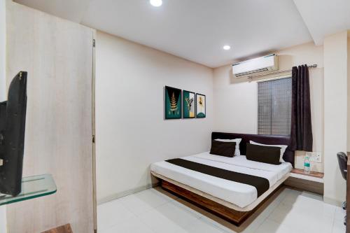 a bedroom with a bed and a tv in it at Hotel O Hotel Krishna's Residency in Indore
