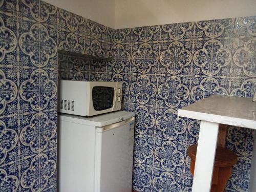 a microwave on top of a refrigerator in a kitchen at Quinta Da Lagoa GuestHouse in Vila Real