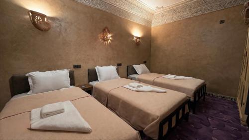 a room with two beds with towels on them at Maison Gourdia in Zouiyya