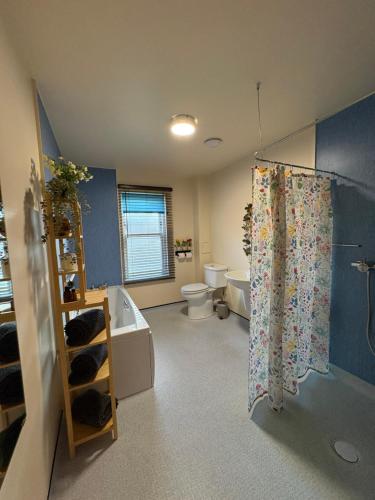a bathroom with a toilet and a tub and a shower at The Rookery in Orkney
