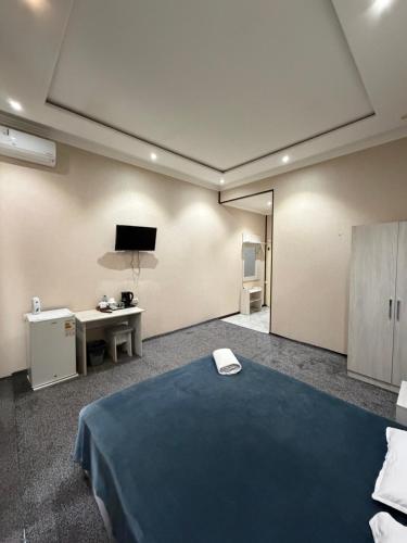 a room with a bed and a desk and a tv at Shoxdiyor in Angren