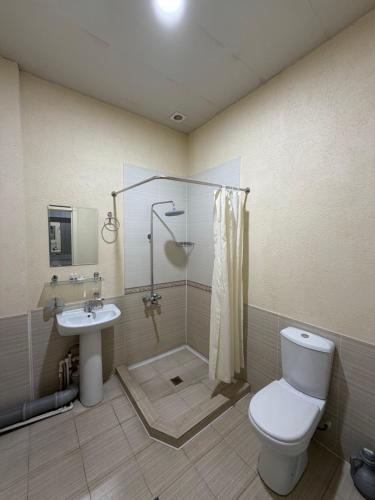 a bathroom with a toilet and a shower and a sink at Shoxdiyor in Angren