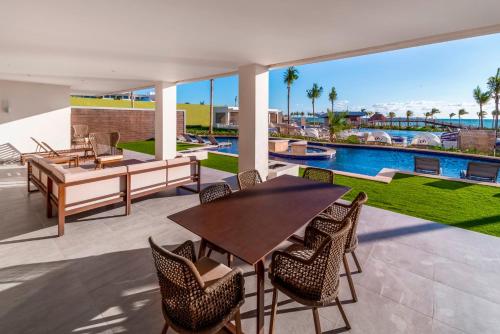 a patio with a table and chairs and a pool at Planet Hollywood Cancun by Royalton, An Autograph Collection All-Inclusive Resort in Cancún