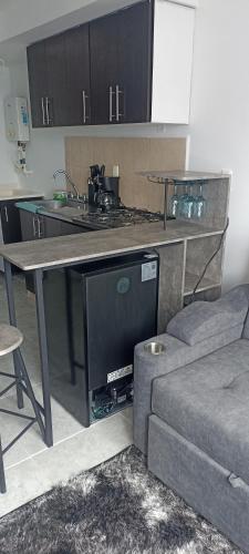 a kitchen with a table with a sink and a couch at Ensueño 904 in Armenia