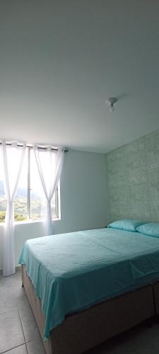 a bedroom with a bed and a window at Ensueño 904 in Armenia