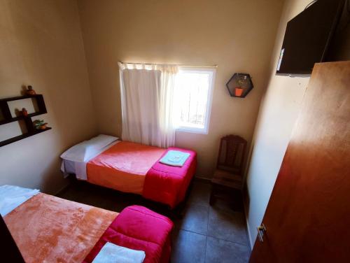 a small room with two beds and a window at Hotel AEROPUERTO Jujuy in Perico