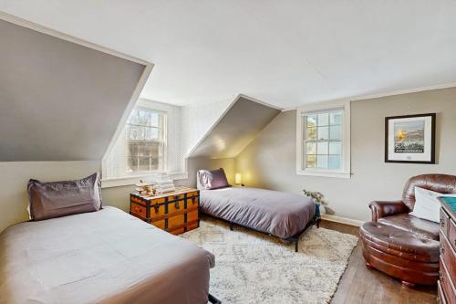 a bedroom with two beds and a couch and a chair at The Hilltop - Main House in Waterbury