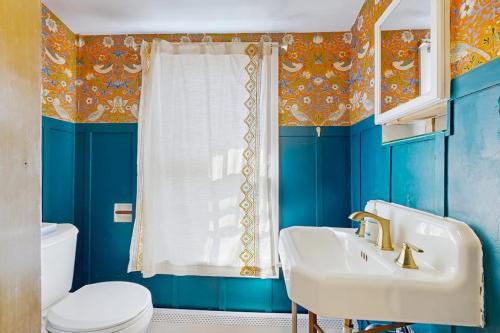 a blue bathroom with a sink and a toilet at The Hilltop - Main House in Waterbury