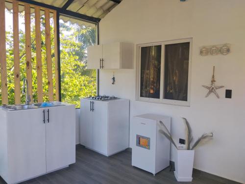 a kitchen with white cabinets and a large window at Residence Xamanai Playa Rincón II in Palmarito