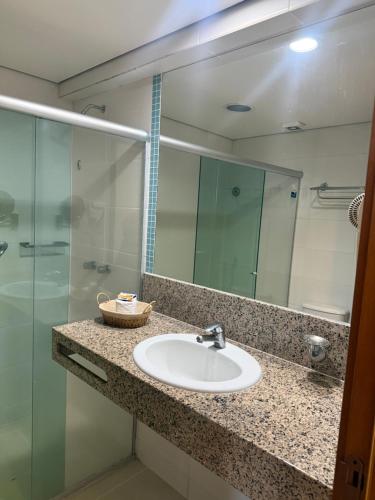 a bathroom with a sink and a glass shower at Flat no Hotel Blue Tree in Manaus